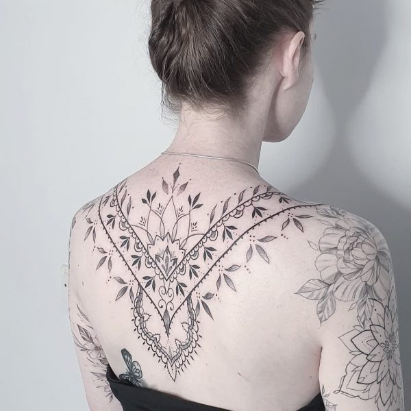 Tattoo artist reviewing pricing and booking schedule at professional tattoo studio in 2026